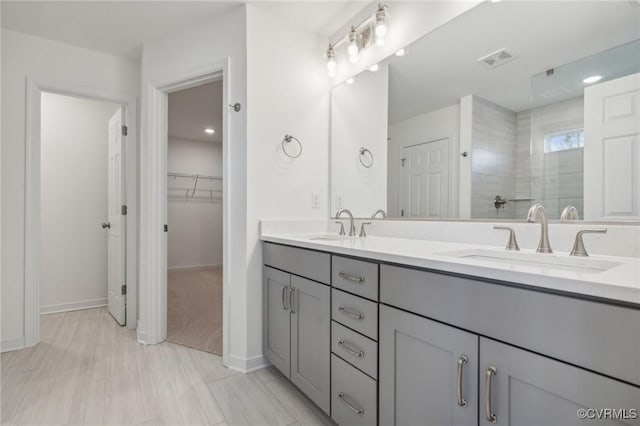 bathroom featuring a tile shower and vanity