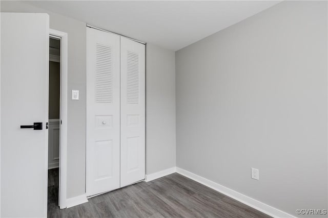 unfurnished bedroom featuring a closet and dark hardwood / wood-style floors