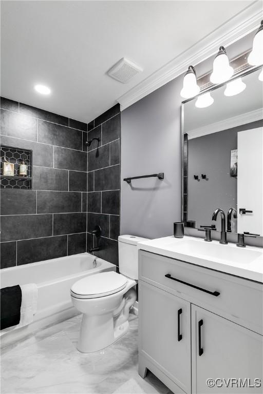 full bathroom with ornamental molding, toilet, vanity, and tiled shower / bath