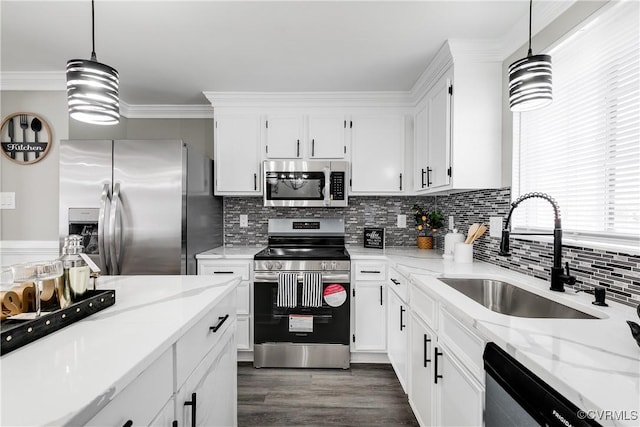 kitchen featuring hanging light fixtures, white cabinetry, appliances with stainless steel finishes, and sink