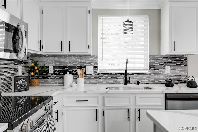 kitchen with hanging light fixtures, white cabinetry, appliances with stainless steel finishes, and sink