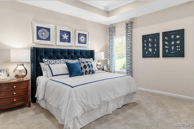 carpeted bedroom with a tray ceiling and ornamental molding