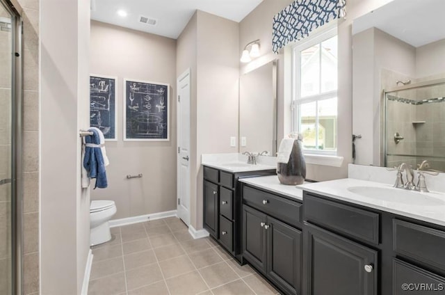 bathroom with tile patterned floors, vanity, toilet, and a shower with door