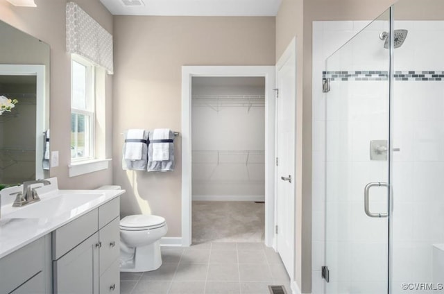 bathroom featuring vanity, toilet, tile patterned flooring, and a shower with door