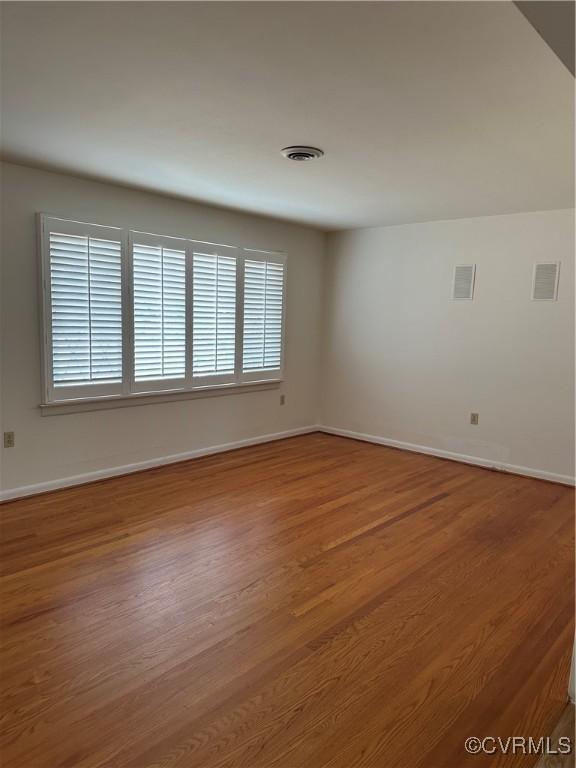 empty room with hardwood / wood-style floors