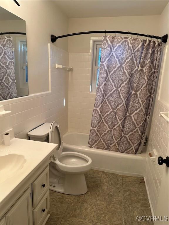 full bathroom with tile walls, tile patterned flooring, vanity, toilet, and shower / bath combo with shower curtain