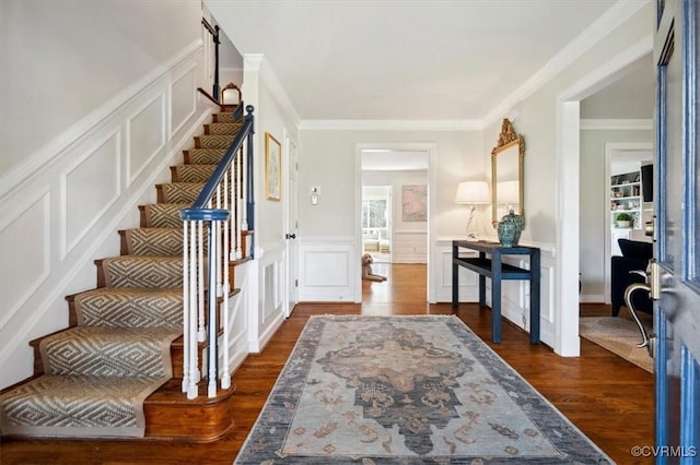 foyer entrance featuring ornamental molding and dark hardwood / wood-style flooring