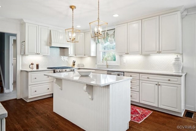 kitchen with white cabinets, a center island, pendant lighting, and custom range hood