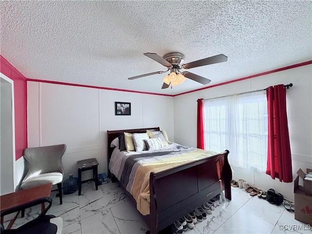 bedroom with ceiling fan and a textured ceiling