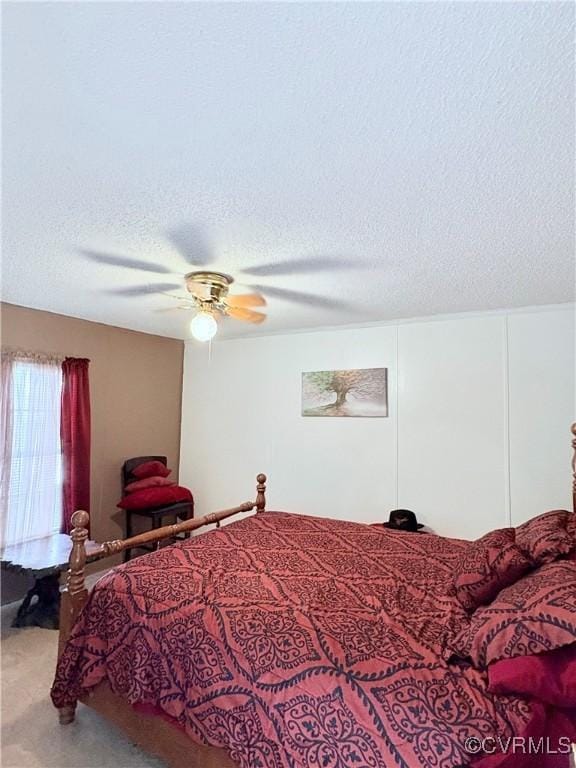 bedroom with ceiling fan and a textured ceiling