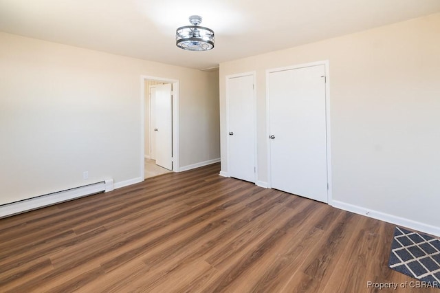 unfurnished bedroom with dark wood-type flooring and a baseboard radiator