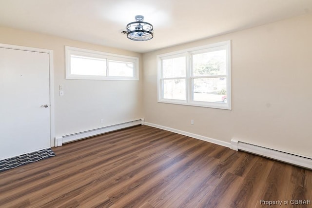 empty room with dark hardwood / wood-style flooring and a baseboard radiator