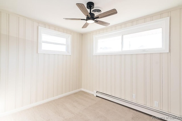 unfurnished room featuring plenty of natural light, a baseboard heating unit, light colored carpet, and ceiling fan