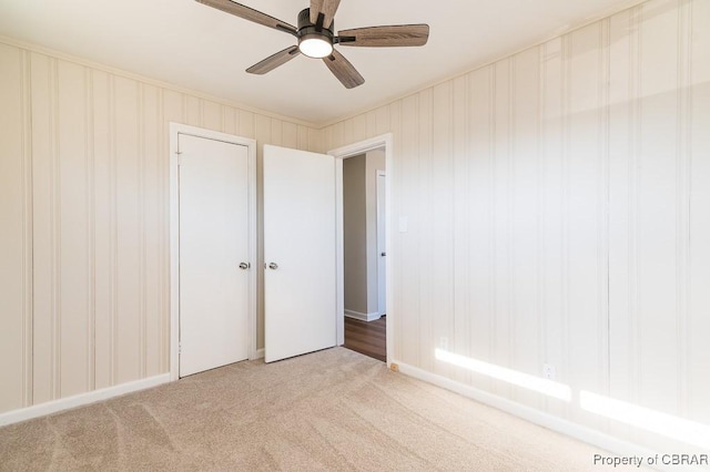 unfurnished bedroom with light carpet, a closet, and ceiling fan