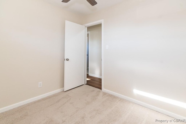 spare room featuring light colored carpet and ceiling fan