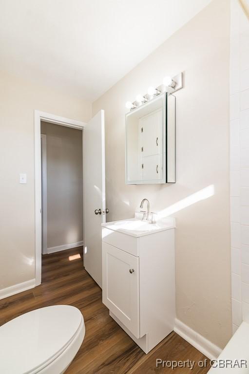 bathroom with vanity, hardwood / wood-style floors, and toilet