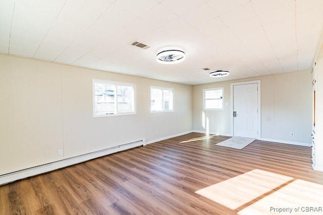 spare room with a baseboard radiator and hardwood / wood-style floors