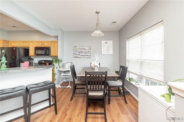 dining space with light hardwood / wood-style floors