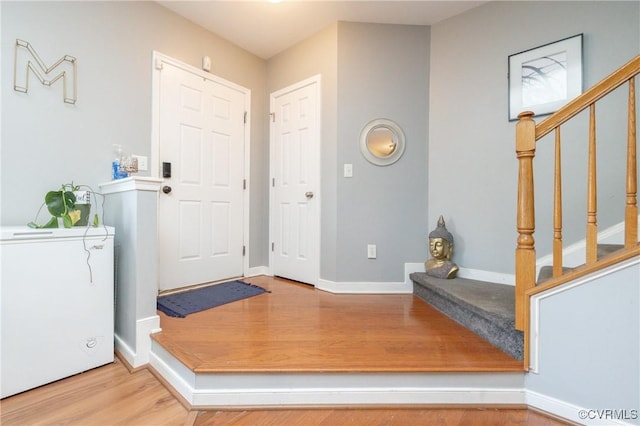 foyer entrance featuring wood-type flooring and washer / dryer