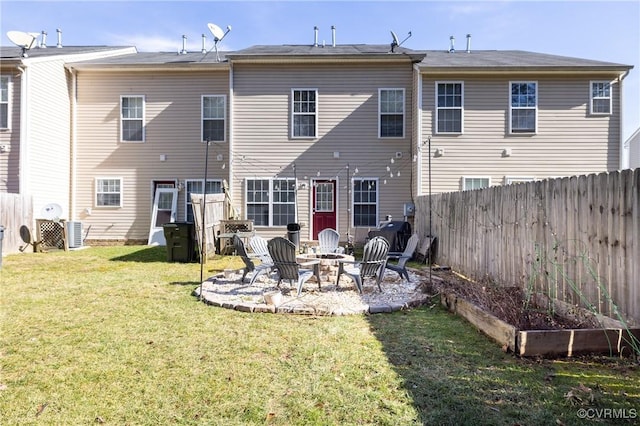 rear view of property with a fire pit and a lawn