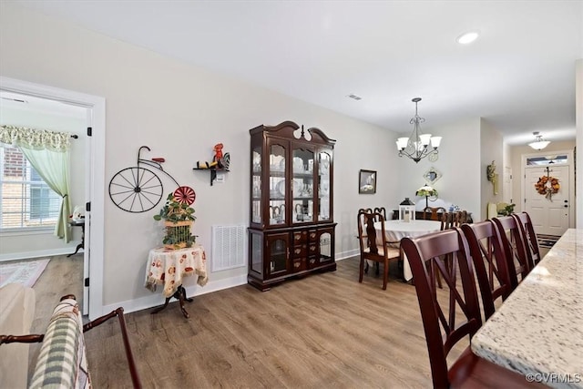 dining room with hardwood / wood-style flooring and a chandelier