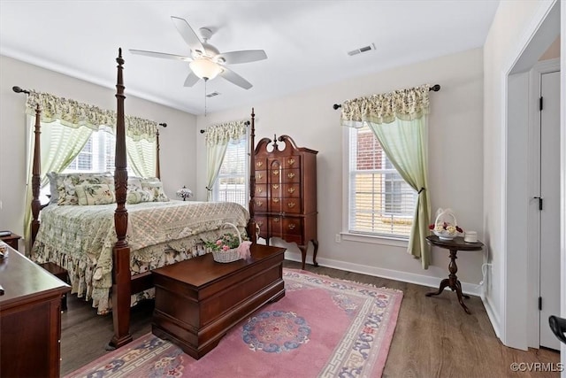 bedroom featuring ceiling fan, dark hardwood / wood-style flooring, and multiple windows