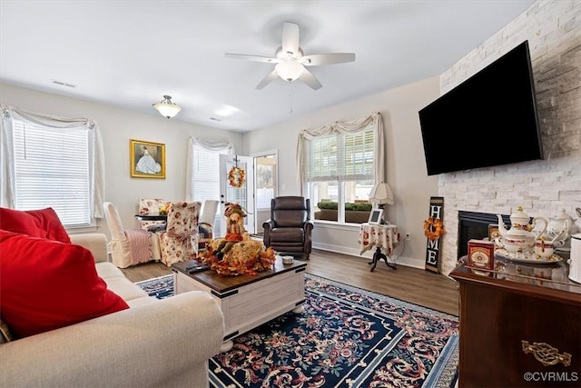 living room with ceiling fan, hardwood / wood-style floors, and a fireplace