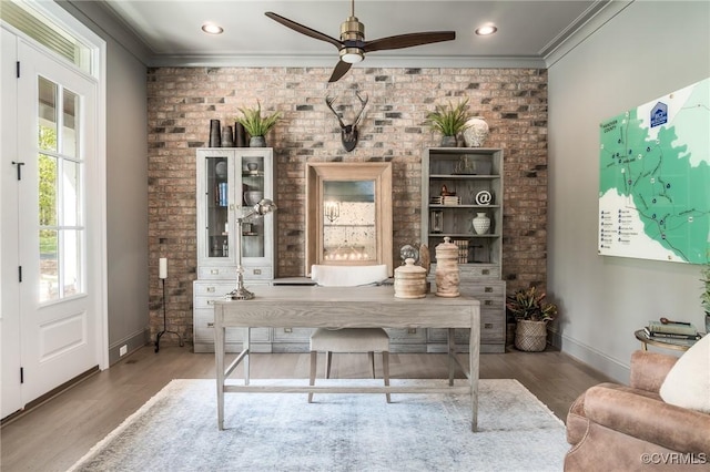 office space with crown molding, wood-type flooring, and brick wall