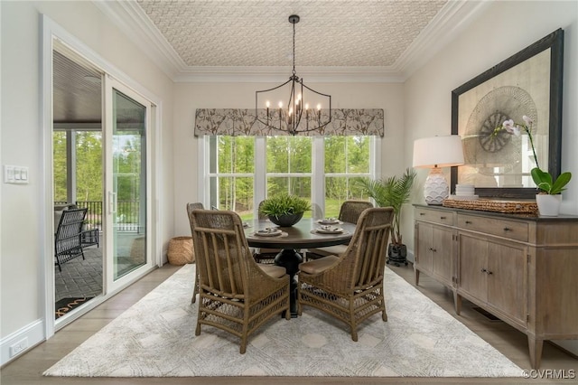 dining room featuring crown molding, plenty of natural light, and a chandelier