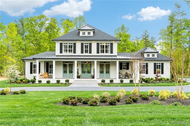 view of front of house featuring a front yard, covered porch, and french doors