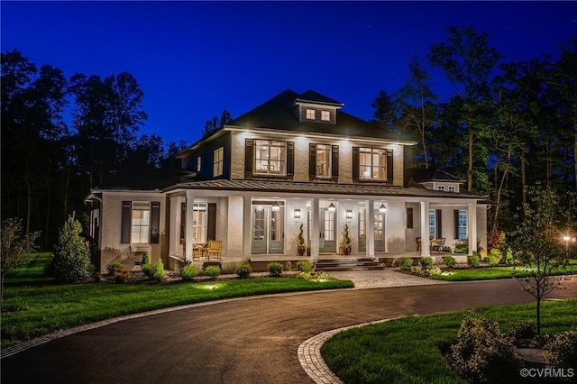 neoclassical / greek revival house featuring a porch and a lawn