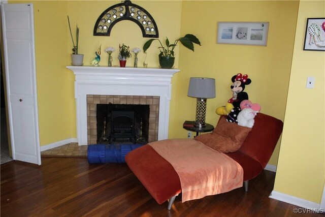 living area with a fireplace and dark hardwood / wood-style flooring