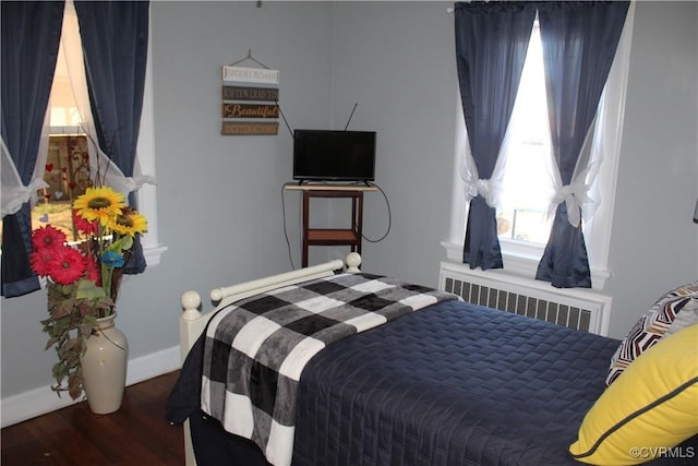 bedroom featuring dark hardwood / wood-style flooring and radiator