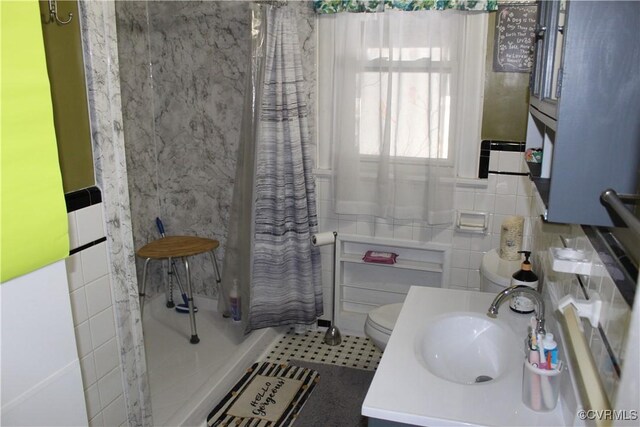 bathroom with vanity, toilet, tile walls, and a shower with curtain