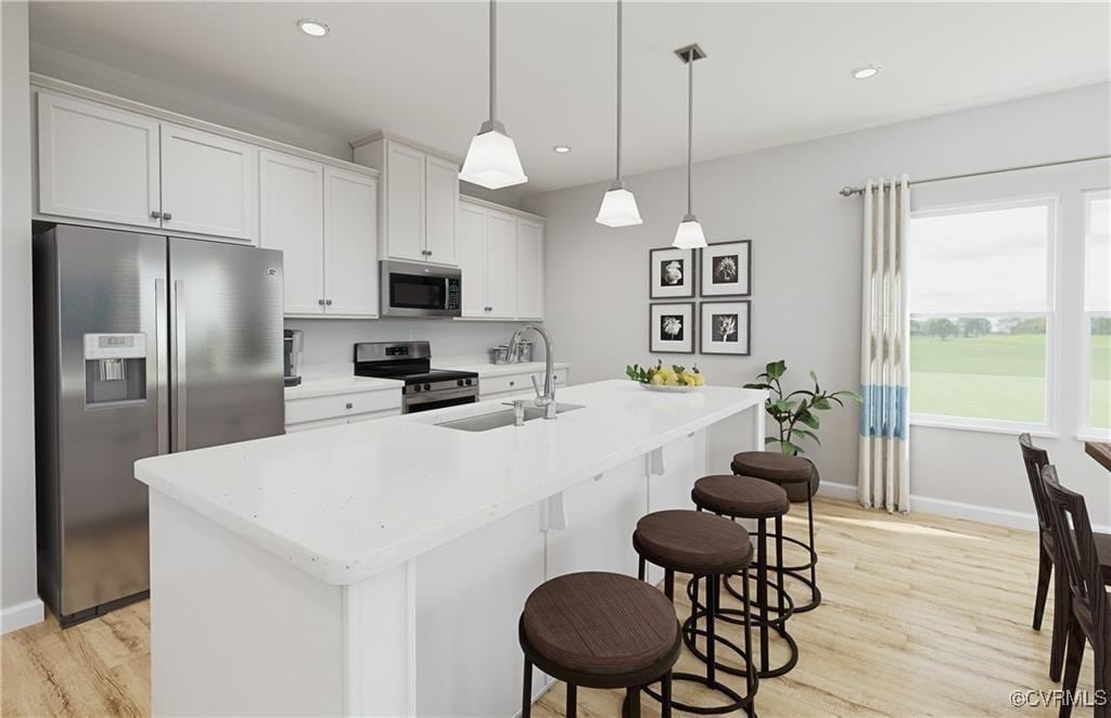 kitchen with white cabinetry, stainless steel appliances, decorative light fixtures, and an island with sink