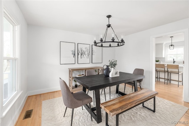 dining space with an inviting chandelier and hardwood / wood-style floors