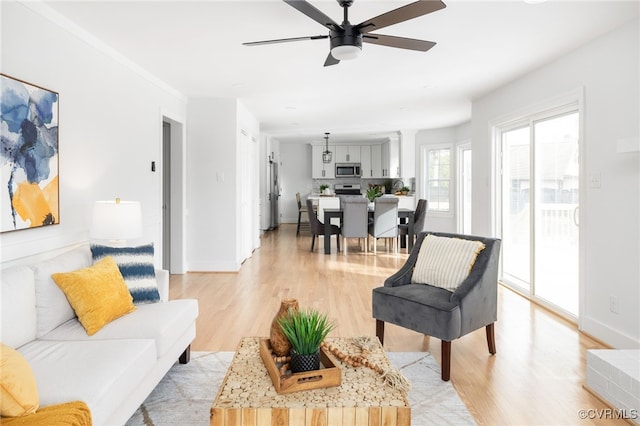 living room with ceiling fan and light wood-type flooring