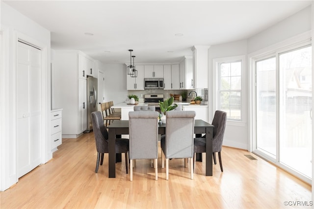 dining space featuring sink and light hardwood / wood-style floors