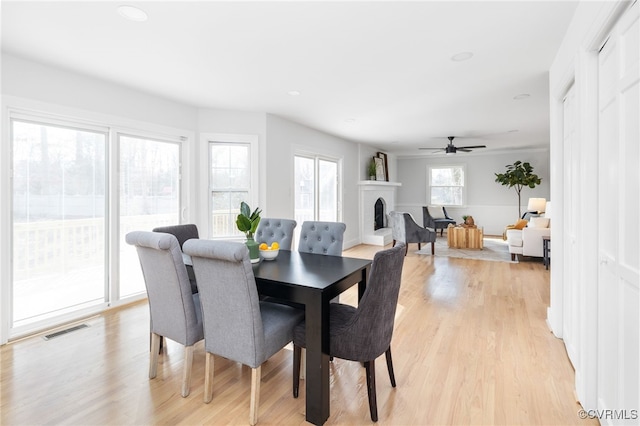 dining area featuring a fireplace and light hardwood / wood-style floors