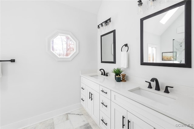 bathroom featuring vanity and vaulted ceiling with skylight