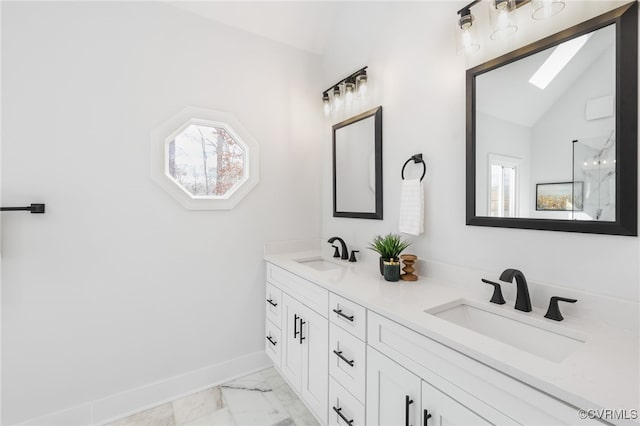 bathroom featuring vanity and vaulted ceiling with skylight