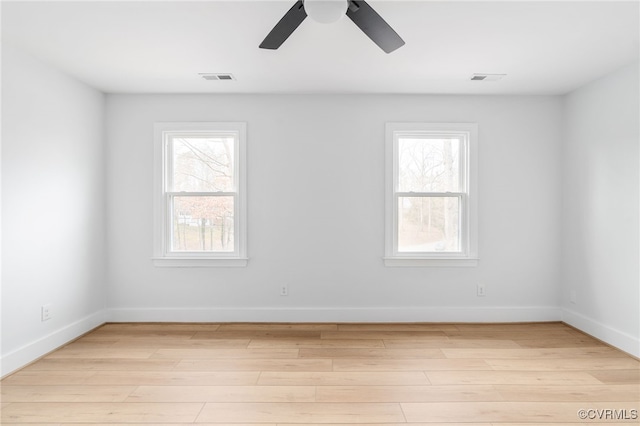 empty room featuring ceiling fan, light hardwood / wood-style floors, and a healthy amount of sunlight