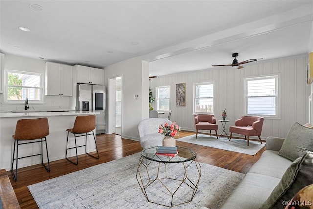 living room featuring ceiling fan, sink, and dark hardwood / wood-style flooring