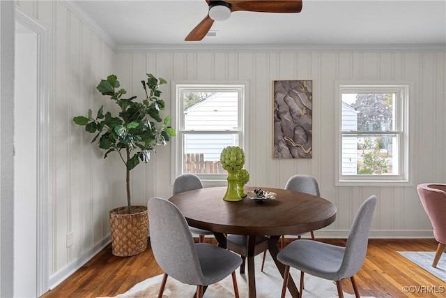 dining room with hardwood / wood-style flooring, ornamental molding, and ceiling fan