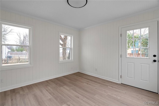 empty room with ornamental molding and light wood-type flooring