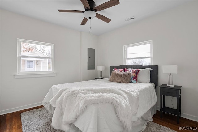 bedroom with electric panel, dark hardwood / wood-style floors, and ceiling fan