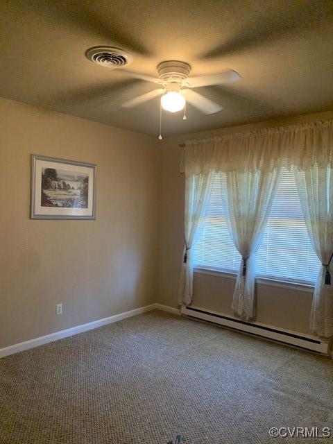 202 W York Dr, Emporia, VA 23847 - spare room featuring a textured ceiling, a baseboard radiator, ceiling fan, and carpet