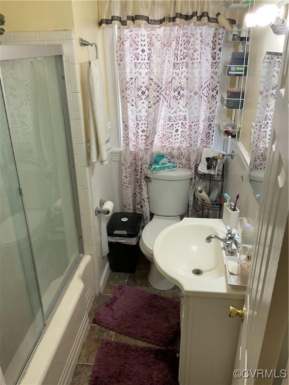 full bathroom featuring bath / shower combo with glass door, vanity, toilet, and tile patterned flooring