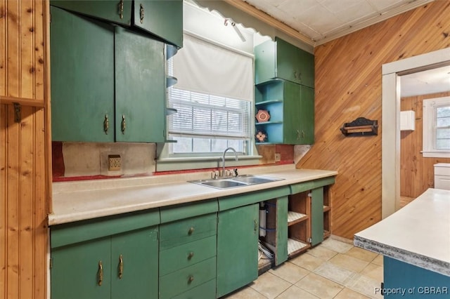 kitchen with wooden walls, tasteful backsplash, sink, light tile patterned floors, and green cabinetry