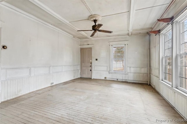 unfurnished room with beamed ceiling, coffered ceiling, ceiling fan, and light hardwood / wood-style flooring